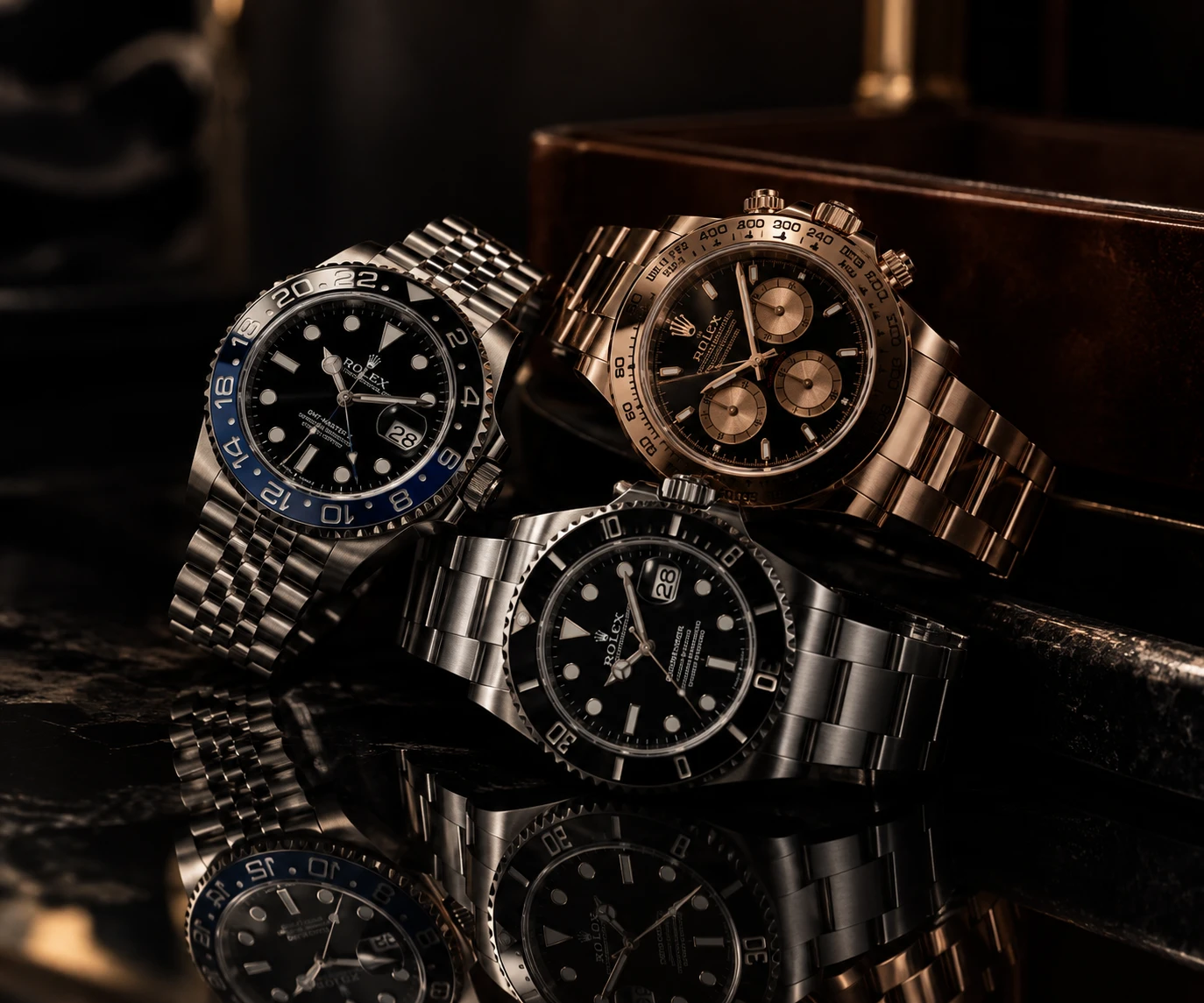 Three Rolex watches on a dark marble surface